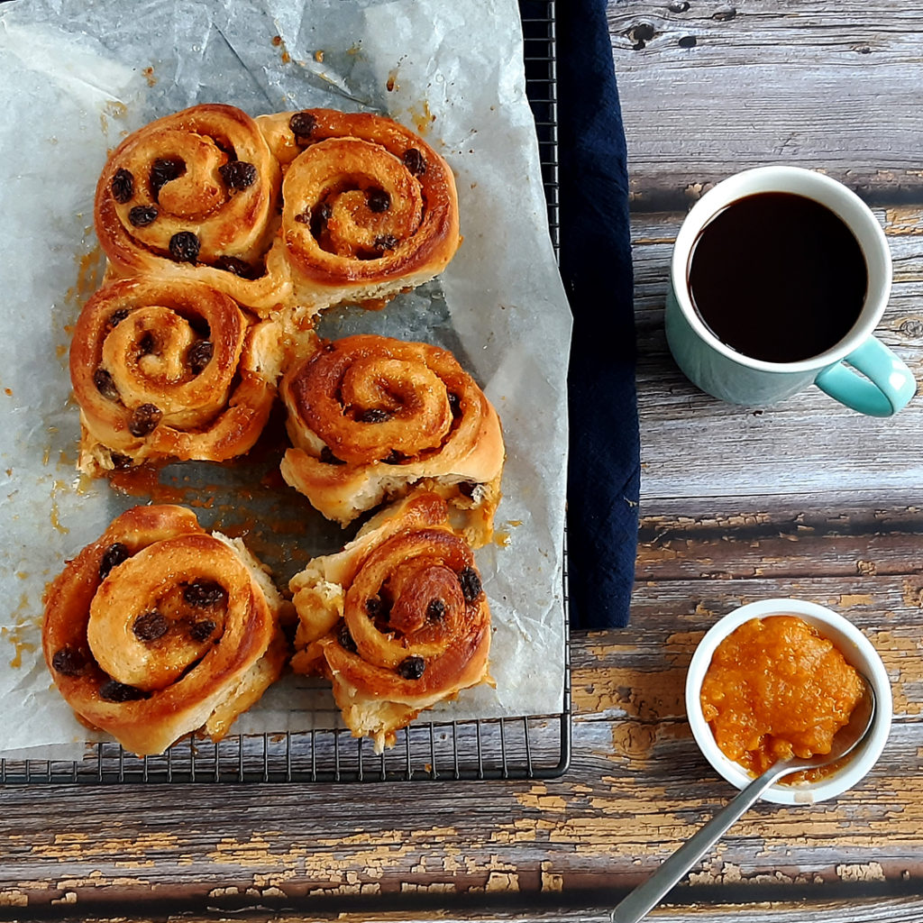 Bunettones next to a cup of coffee and some citrus paste