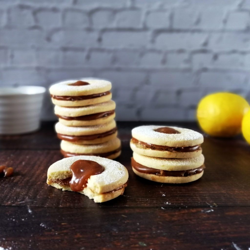 Salted caramel and lemon sandwich biscuits stacked and half eaten