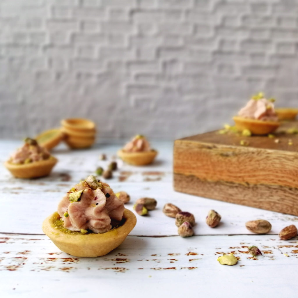 Mortadella and pistachio mini tartlet side shot with other tartlets in the background