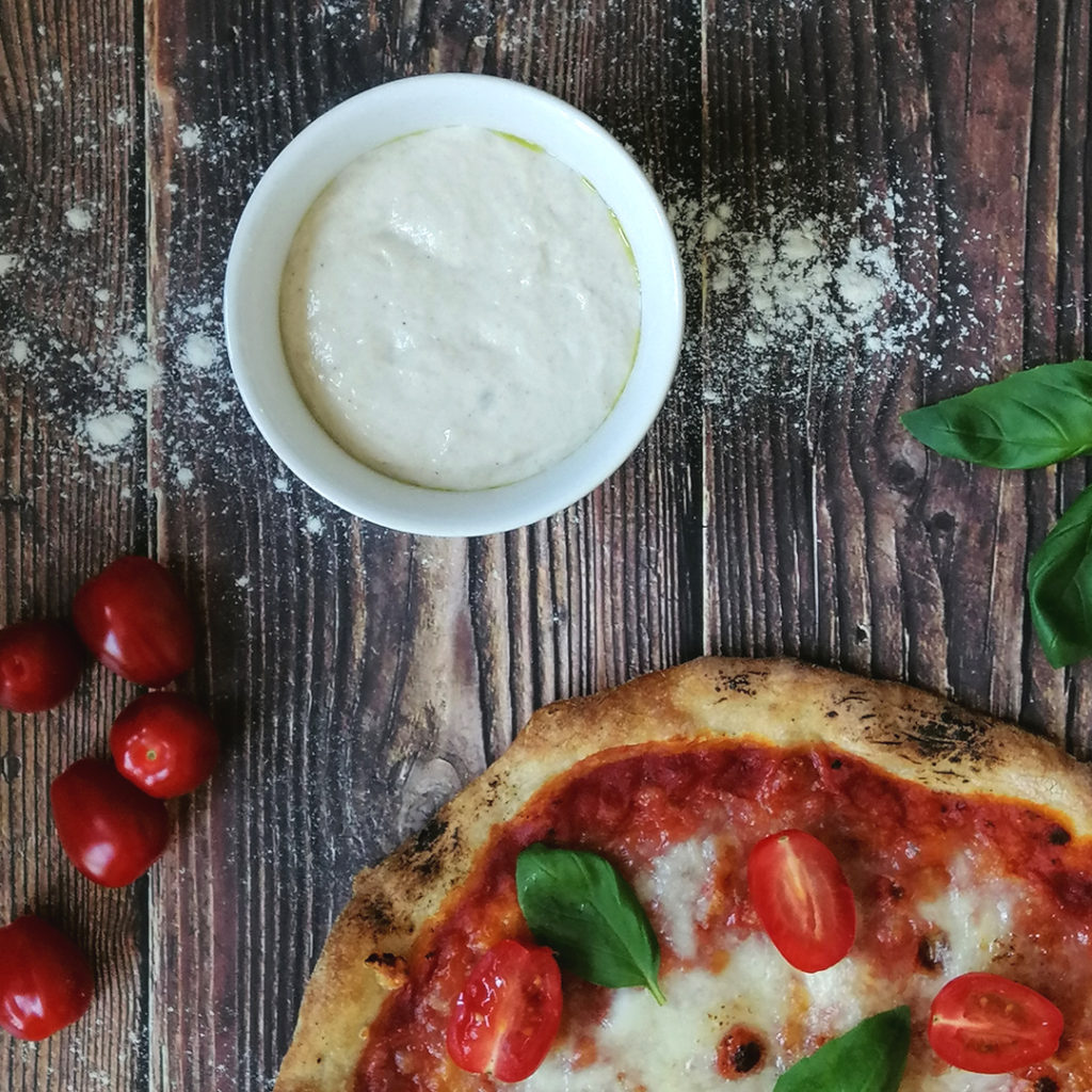 Sourdough pizza dough ball, portion of pizza margherita with cherry tomatoes and basil leaves