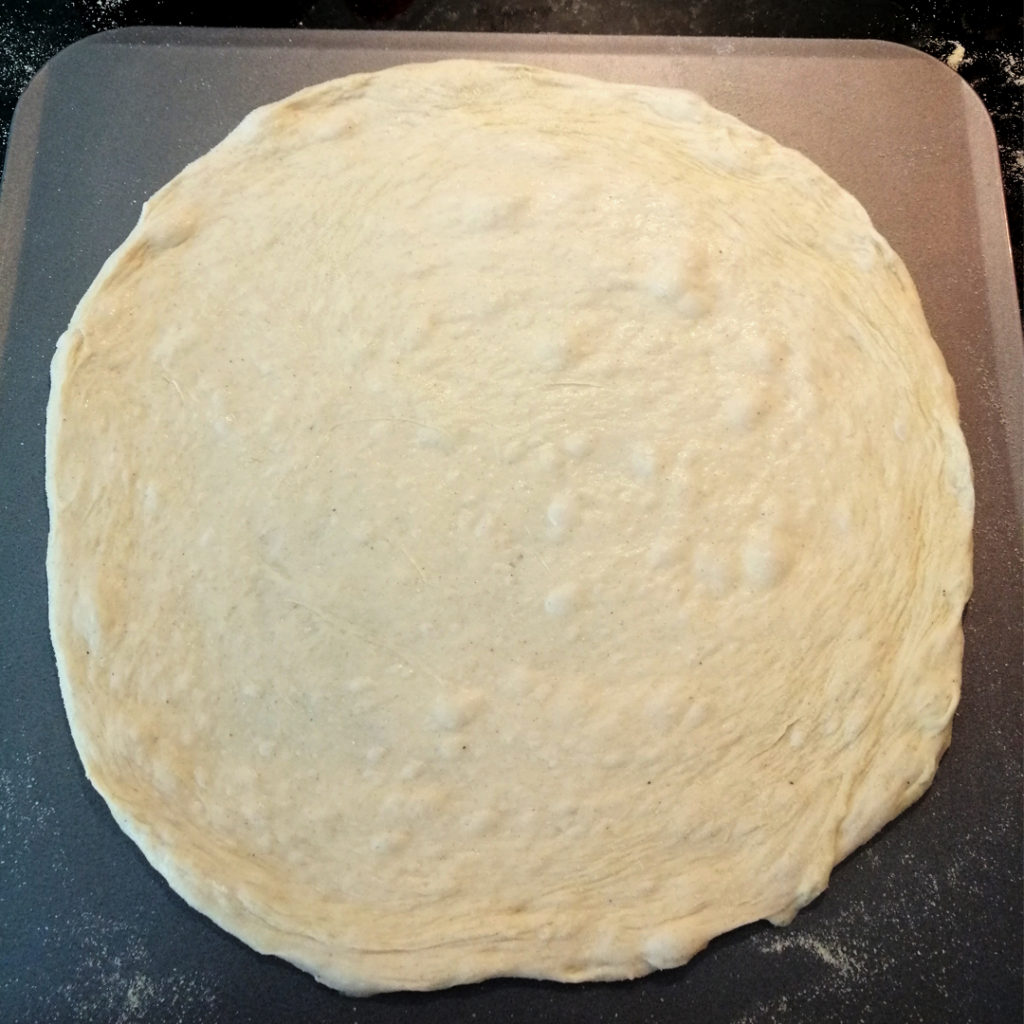 Flattened pizza base ready for being garnished and baked