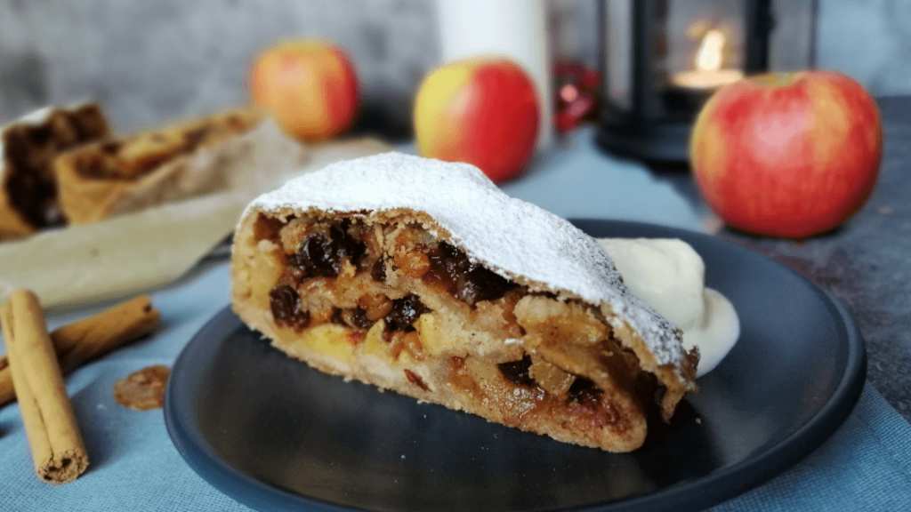 Slice of strudel seen rom the side, showing the thin pastry and the filling of mincemeat and apples.