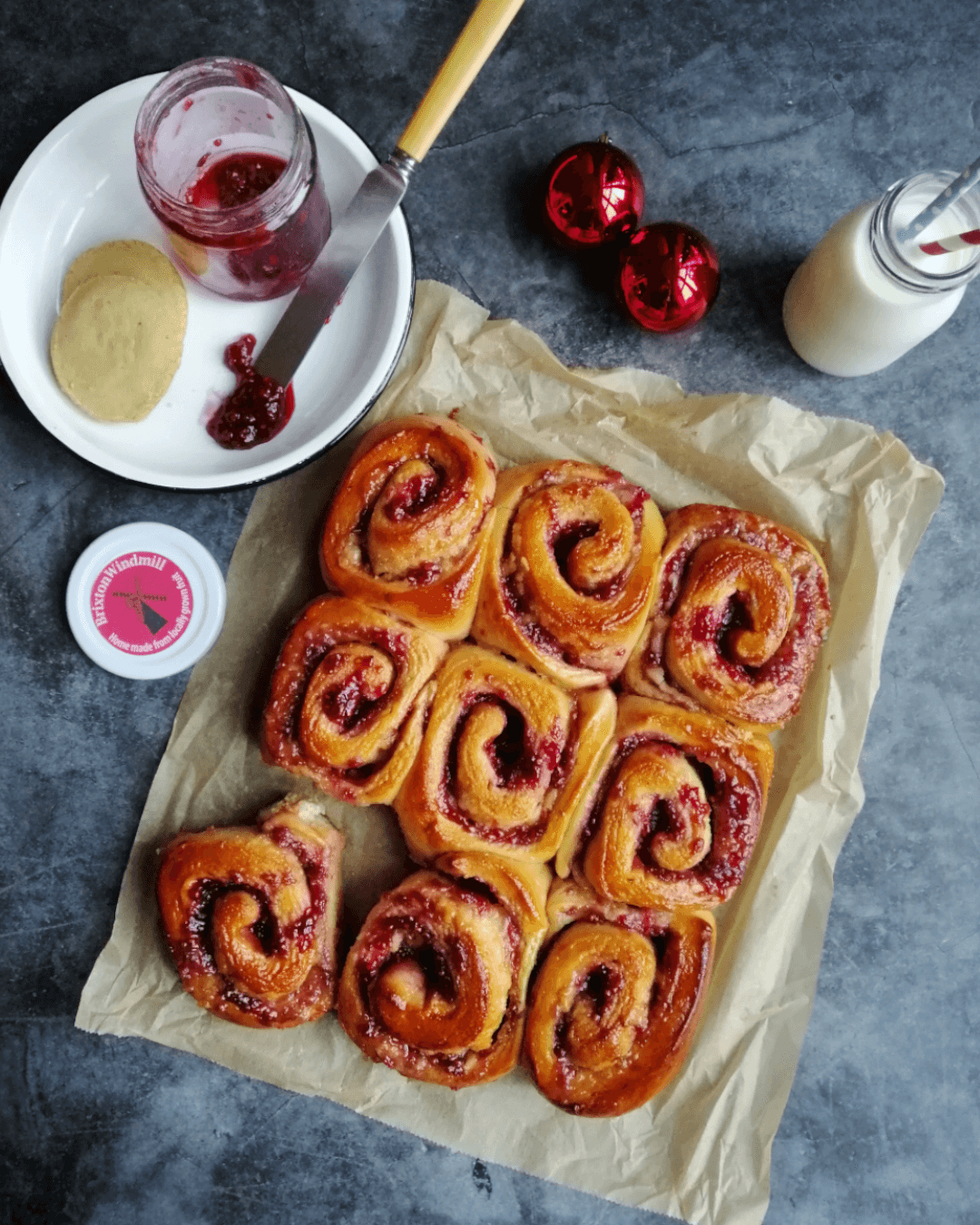 Jam and marzipan sticky buns out of the oven on a baking parchment. Copyright The Italian bkr